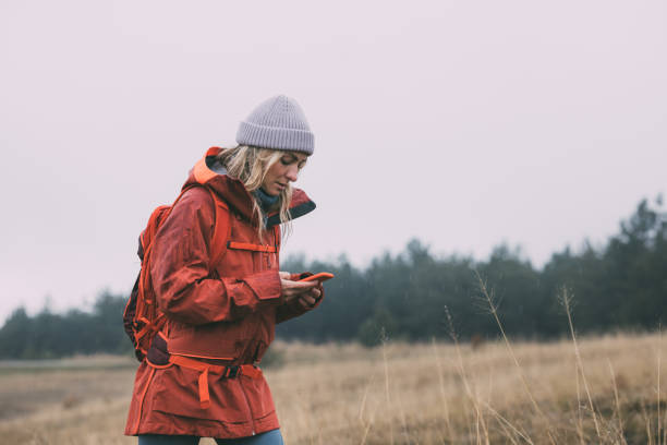 istock Beautiful Female Hiker Exploring the Mountains, Using her Smartphone to Navigate 1349823051