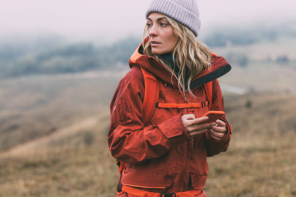 istock Beautiful Female Hiker Exploring the Mountains, Using her Smartphone to Navigate 1349823060
