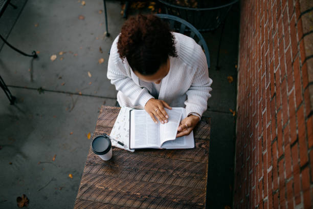 mujer estudiando en un café urbano al aire libre - christian mujer leyendo la biblia fotografías e imágenes de stock
