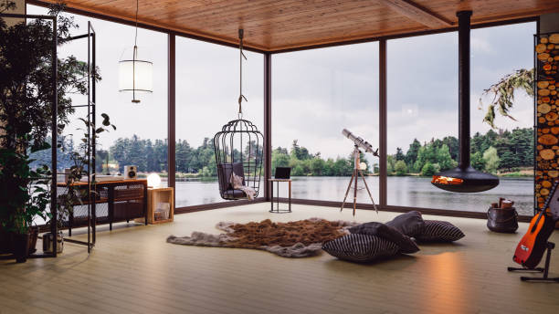 Cozy Lake House Living Room With Lake View Interior of a modern cozy lake house with fireplace and indoor plants. chalet stock pictures, royalty-free photos & images