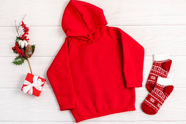 Czerwona bluza z kapturem w komplecie ze skarpetkami i świątecznym pudełkiem, idealna na chłodne wieczory przy ognisku.