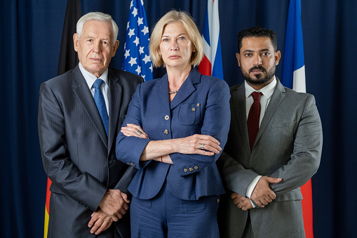 Team leader stands with coworkers in background..isolated on a white background.