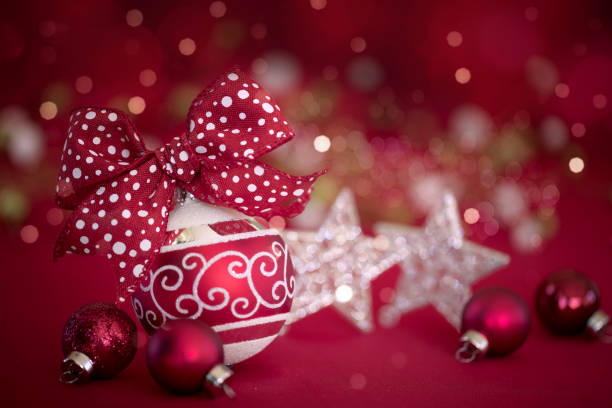 istock Christmas Red Bauble with a Bow on a Red Bokeh Lights Background 1349859462
