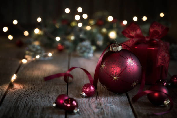 istock Christmas Gift and Red Baubles on a Rustic Wood Background 1349860119