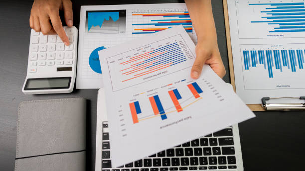 istock Businessmen use laptops and calculators to analyze graphs and calculate reports, company financial budgets and plan for the future in a successful work concept office. 1349874263