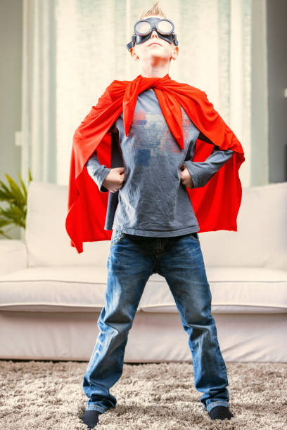 istock Proud young Super Hero posing in a red cape and goggles 1349874442