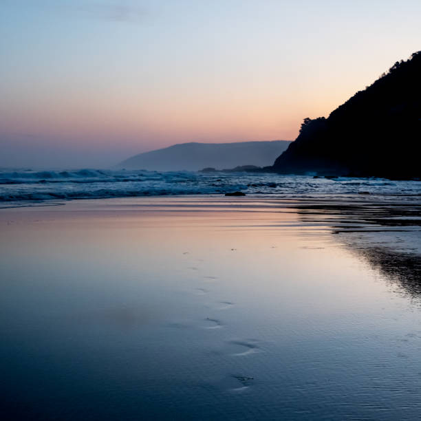 Footprints in sand leading from the sea.  Just after sunset along Australia's Great Ocean Road near Lorne, Victoria