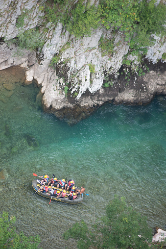 Durmitor,Montenegro-September 8th 2019: Beneath the high Tara Canyon Bridge,ten thrill seeking tourists in an inflatable raft, tackle the rapid waters of Tara River gorge,in late summer.
