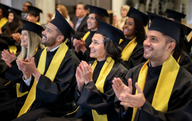 istock Happy group of graduates clapping in their graduation ceremony 1349878791