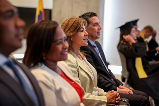 Proud Latin American parents smiling at a graduation ceremony - education concepts