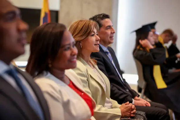 Photo of Proud parents looking happy at a graduation ceremony