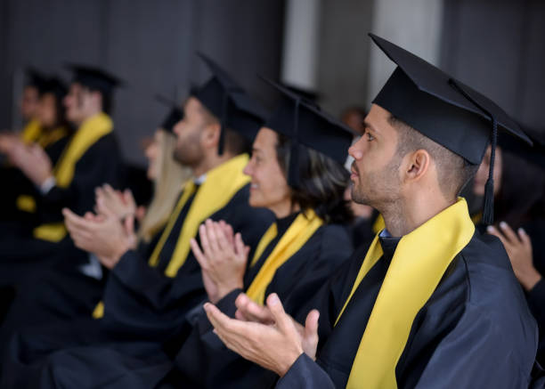 istock Happy group of graduate students clapping in their graduation ceremony 1349878820
