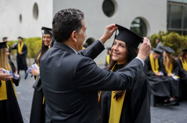 stolzer vater arrangiert den mörserbock ihrer abschlusstochter - graduation color image people photography stock-fotos und bilder