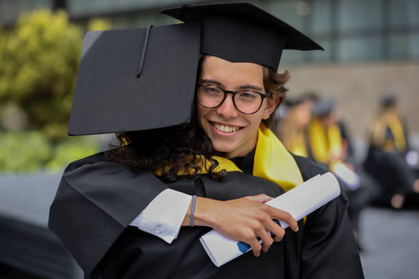 istock Happy man hugging a friend after graduating together 1349878851