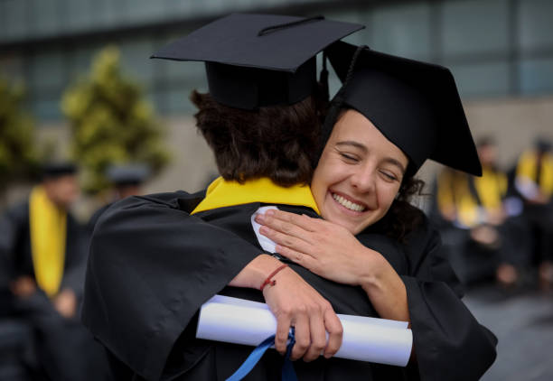 istock Happy students hugging after graduating together 1349878852