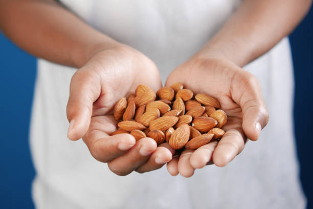 istock close up of almond nuts on man's hand 1349878868