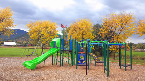 Colorful Children's climbing set at a playground in a rural community. Barn in Background. Coldstream,Vernon, BC.