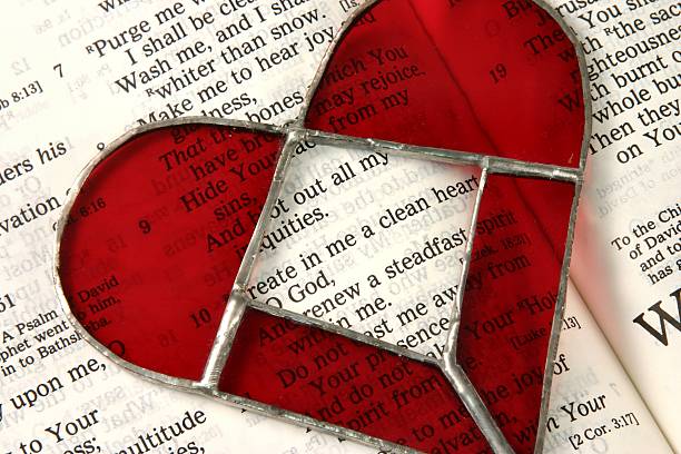 Open Bible and red Stained glass heart with the verse from Psalm 51 saying \