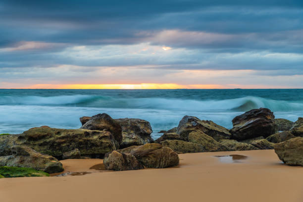 istock Low cloud covered sunrise seascape with rocks 1349887610