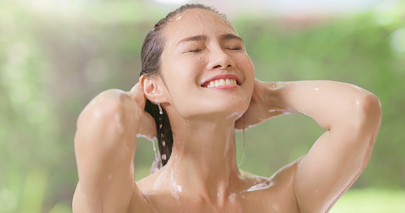 closeup of beauty girl is taking shower and use hands to touch her neck