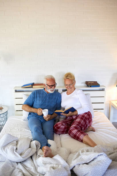 istock Senior couple reading a book in bed before going to sleep 1349898310