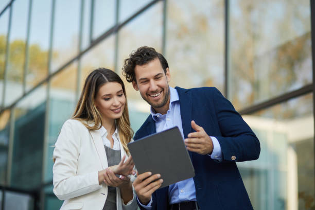 istock Business couple working online outdoors on a tablet computer 1349898394