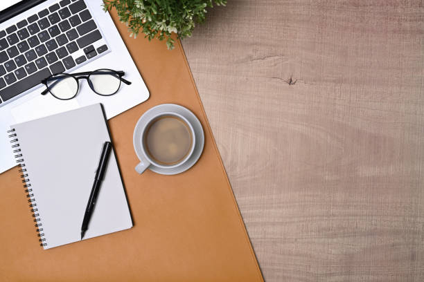 istock Simple workspace with laptop computer, notebook and coffee cup on wooden table. 1349898479