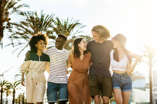 istock Millennial group of friends walking embraced while laughing outdoors in summer - Happy young people celebrating together while talking in the beach - Unity and youth lifestyle concept 1349904152