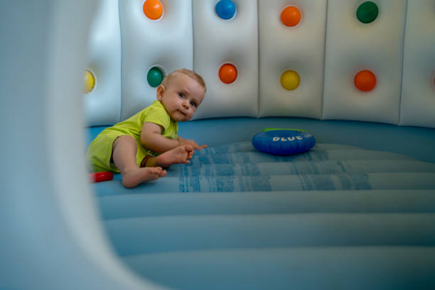 istock Child on colorful playground trampoline 1349905980