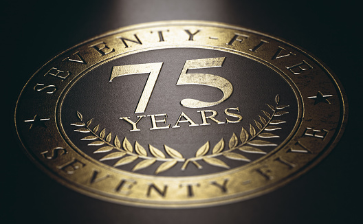 Golden marking over black background with the text 75 years. Concept for a 75th anniversary celebration announcement. 3D illustration.