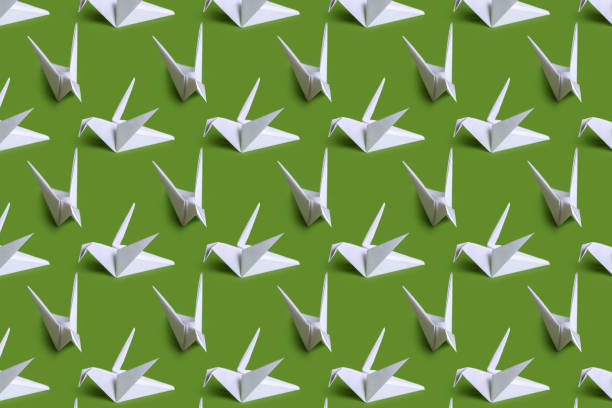 seamless background with paper cranes. white paper birds on a plain background. crafts from paper with children. classic origami - origami crane imagens e fotografias de stock