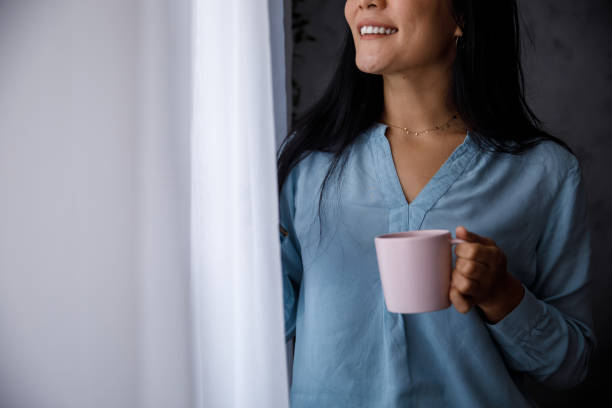 istock Woman looking out the window while enjoying a cup of coffee 1349909127