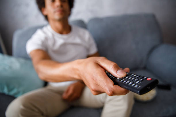 istock Man changing channels on TV he is watching 1349910718
