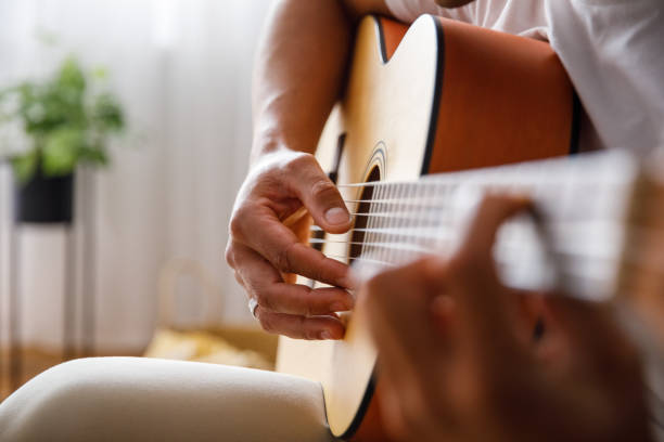 istock Man effortlessly playing chords on acoustic guitar 1349910820