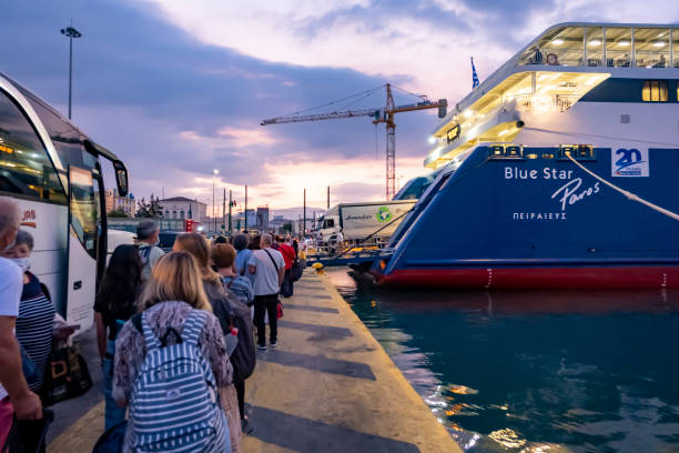 persone in attesa in fila per imbarcarsi sul catamarano paros di blue star ferries al crepuscolo - passenger ship ferry crane harbor foto e immagini stock