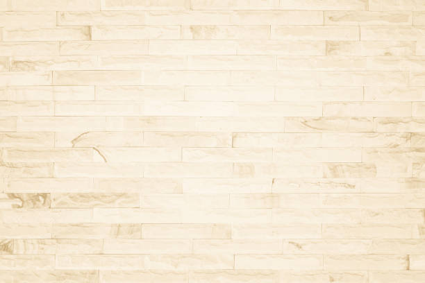 istock Empty background of wide cream brick wall texture. Beige old brown brick wall concrete or stone textured, wallpaper limestone abstract flooring/Grid uneven interior rock. Home decor design backdrop. 1349913702