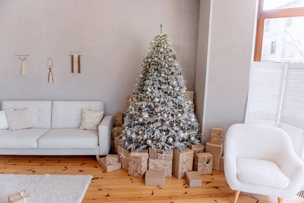 istock Classic modern festive interior in Scandinavian, rustic style. Christmas tree stands by white sofa 1349913757
