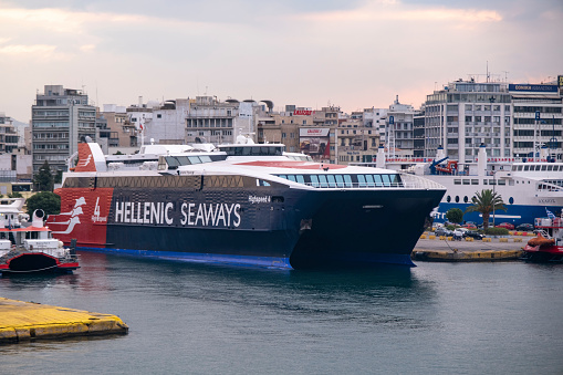 Piraeus, Athens, Greece -09.22.2021: Transportation concept. Greek ferry series. Different cargo and passenger ships. High speed catamaran traveling and connecting Aegean Islands with main land. Nautical background with copy space