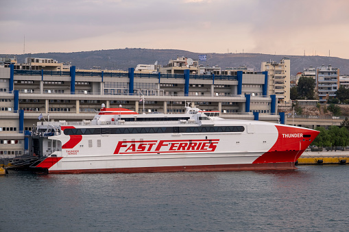 Piraeus, Athens, Greece -09.22.2021: Transportation concept. Greek ferry series. Different cargo and passenger ships. High speed catamaran traveling and connecting Aegean Islands with main land. Nautical background with copy space