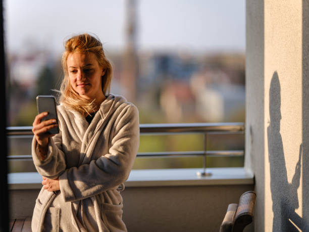 istock Smiling woman using cell phone on a terrace. 1349920170
