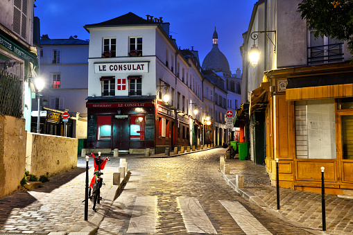 Exterior of the famous cafe Le Consulat at night in Montmartre, Paris. The cafe was visited by plenty of the acclaimed artists, writers and painters that flocked to the area in the 19th century, include Picasso, Sisley, Van Gogh, Toulouse-Lautrec and Monet