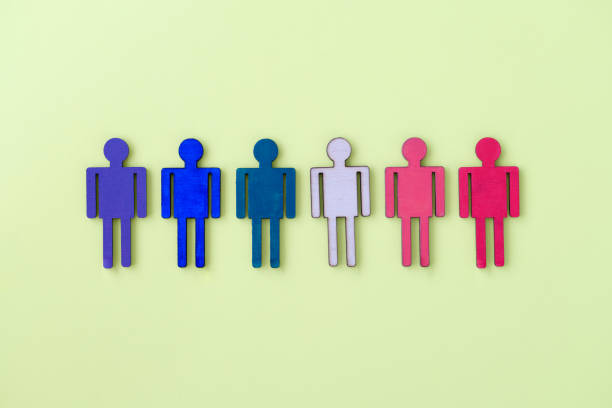 istock Multi-colored wooden figurines of man on yellow background 1349921532