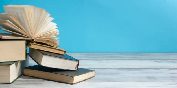 istock Open book, hardback books on wooden table. Back to school. Copy space. 1349923478