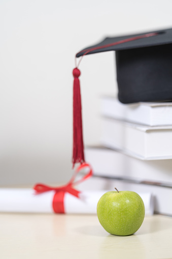 Close-up of a mortarboard and degree certificate on the table. Education Concept Stock Photo