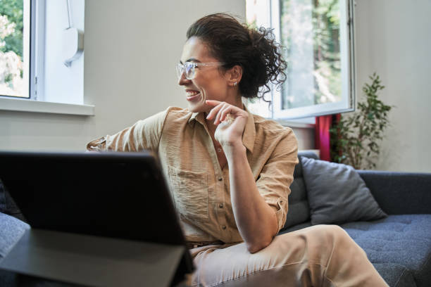istock Happy female therapist looking at the window and smiling while chatting online 1349926245