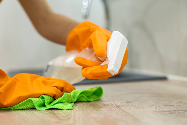 istock Woman in yellow gloves cleans surface standing at kitchen 1349927665