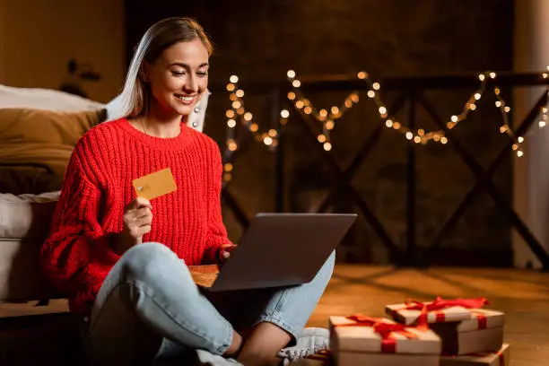Photo of Xmas Shopping. Smiling lady using laptop showing credit card