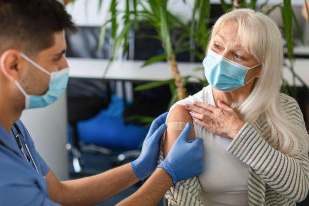 istock Senior Lady Getting Vaccinated Against Covid, Doctor Applying Adhesive Bandage 1349934972