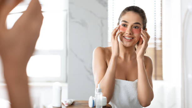 istock Attractive Lady Applying Patches Moisturizing Skin Under Eyes In Bathroom 1349937688