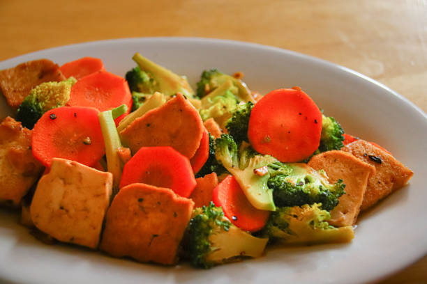 Vegan Stir-fry Tofu and Veggies Close up of stir-fried tofu, carrots and broccoli cambodia food stock pictures, royalty-free photos & images